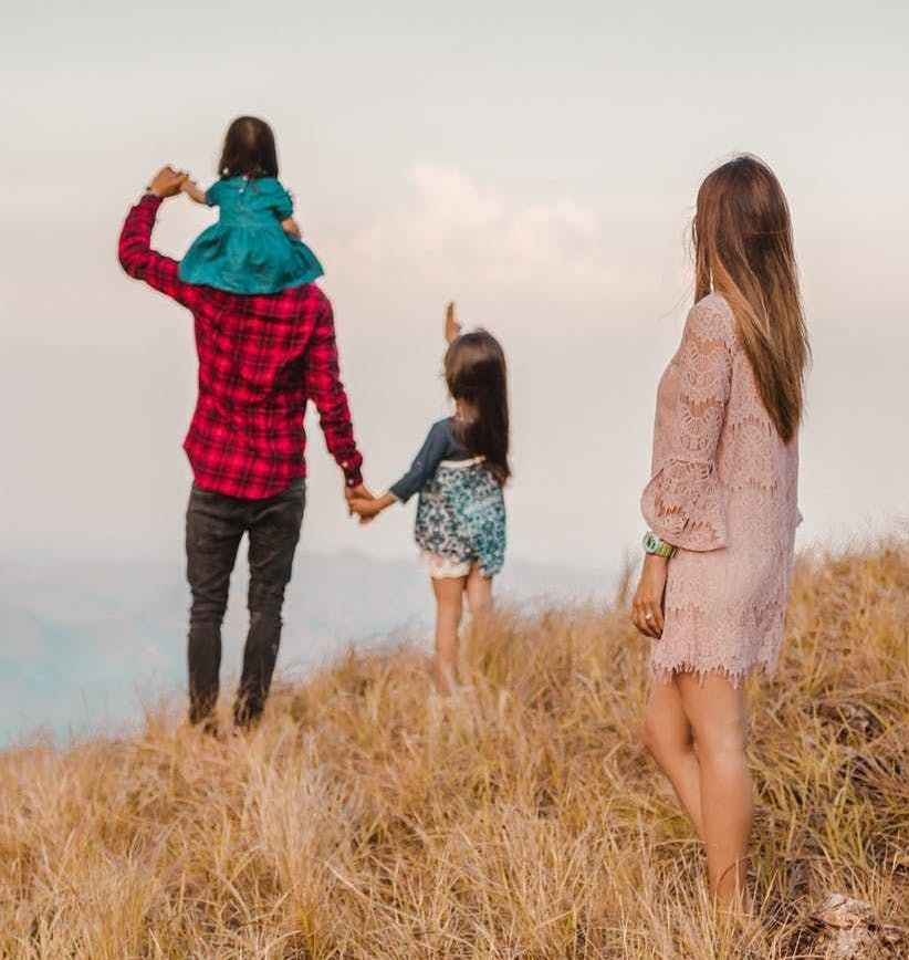 family standing on brown grass